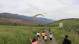 Yamaç paraşütçüler Amanos Dağları'nın eteklerinden depremzede çocuklar için havalandı
